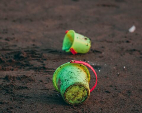 two green pails on ground