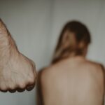 fist of crop man near helpless anonymous woman
