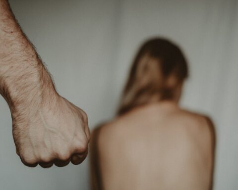 fist of crop man near helpless anonymous woman