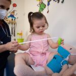 A pediatrician examines a toddler at a medical clinic