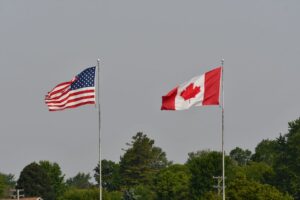 Flags of Canada and the United States flying side by side at the Canada–U.S. border
